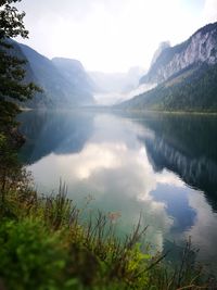 Scenic view of calm lake and mountains against sky