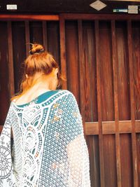 Rear view of woman standing against wall