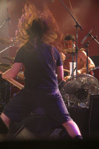 Rear view of woman sitting at music concert