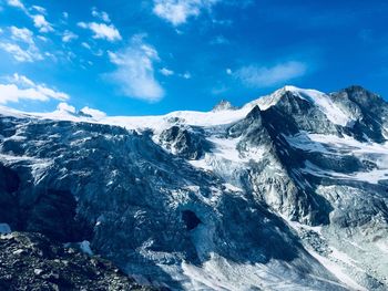 Scenic view of snowcapped mountains against blue sky