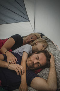 Family sleeping with closed eyes in tent during camping