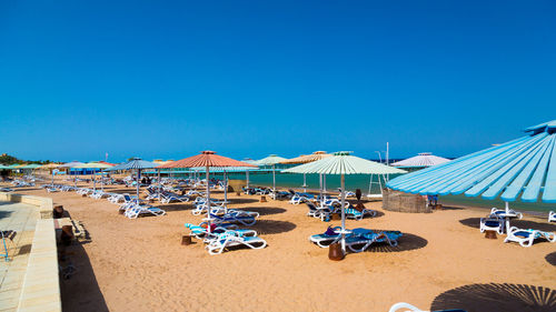 Sun loungers with canopies in row at beach