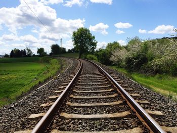 Railroad track amidst trees against sky