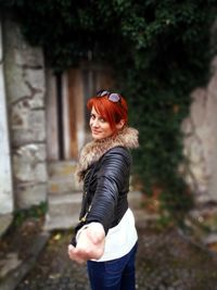 Portrait of smiling beautiful woman wearing jacket while standing outdoors