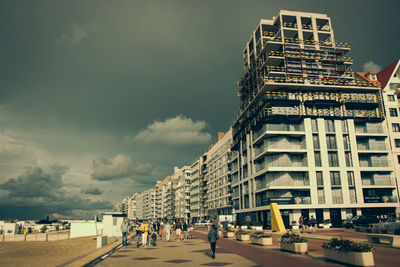 People on street against buildings in city