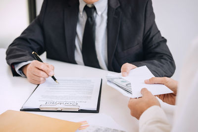 Cropped hands giving money to businessman