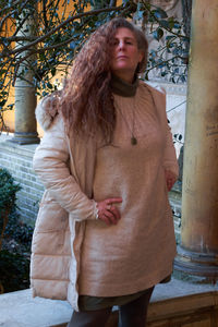 Happy woman standing against tree