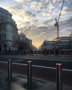 View of city street against cloudy sky