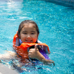 Portrait of cute boy swimming in pool