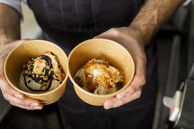 Chef holding dessert in disposable container at restaurant