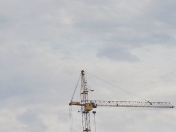 Low angle view of crane against sky