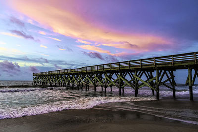 Pier over sea against sky during sunset