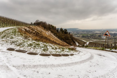 Road in the vineyards against sky during winter