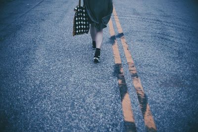 Low section of woman standing on road