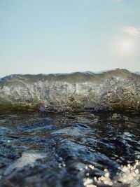 Surface level of rocks in sea against clear sky