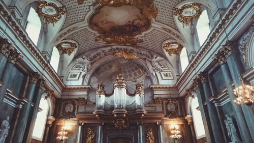 Low angle view of ornate ceiling and organ