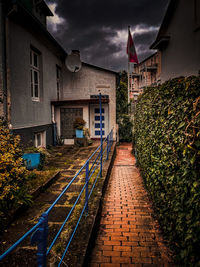 Street amidst houses and buildings against sky