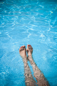 Low section of man relaxing in swimming pool