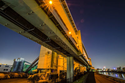 Illuminated bridge against sky at night