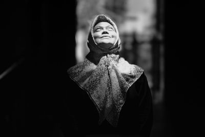 Woman in hijab looking up at darkroom