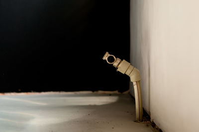 Close-up of cigarette on table against wall