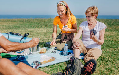 Young woman and senior woman playing cards in family during an excursion