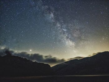 Scenic view of mountains against sky at night