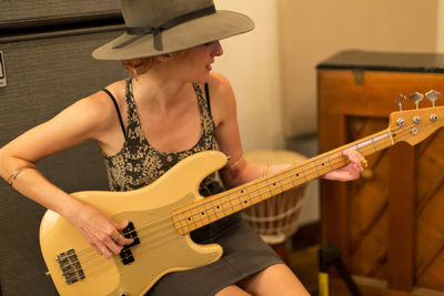 Young female musician playing a bass guitar