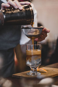 Close-up of hand pouring wine in glass