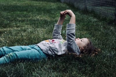 Girl lying on grassy field