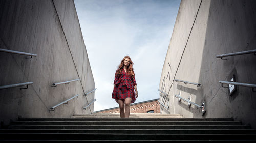 Rear view of woman standing in tunnel