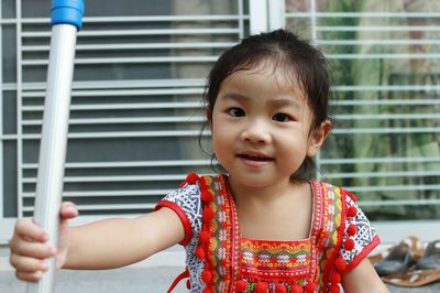 Portrait of smiling girl standing against wall