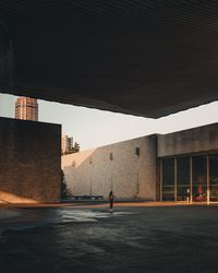 Rear view of man walking on street against buildings in city