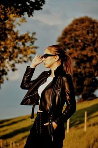 Young woman looking away against sky