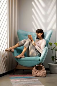 Portrait of young woman sitting on sofa at home