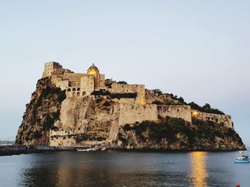 Historic building by sea against clear sky