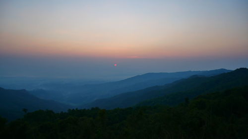 Scenic view of silhouette mountains against sky at sunset