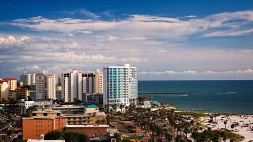 Cityscape by sea against sky