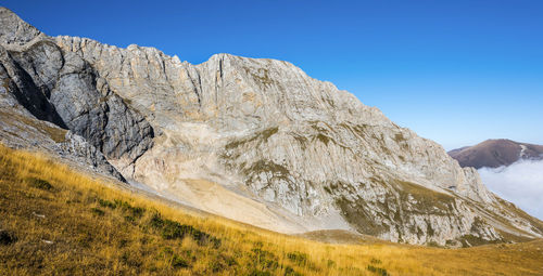 Scenic view of mountains against clear blue sky