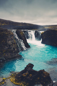 Scenic view of waterfall against sky