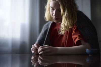 Pensive teenage girl picking at nails