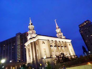 Low angle view of illuminated building against blue sky