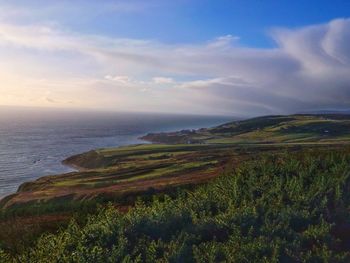 Scenic view of landscape against cloudy sky