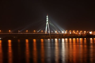 View of bridge over river at night