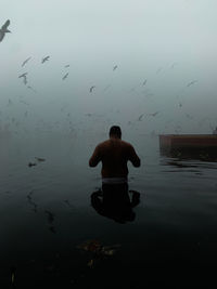 A devotee performing morning rituals on the ghats of yamuna