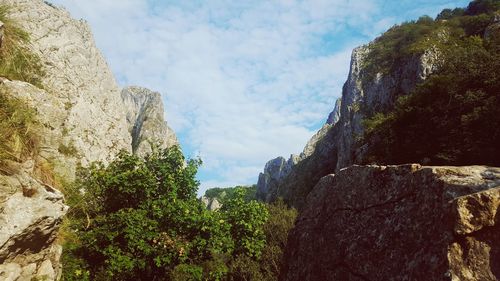 Low angle view of rocky mountains against sky