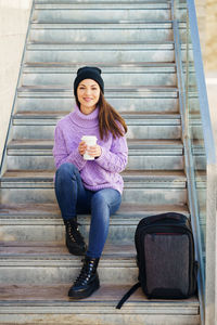 Portrait of young woman sitting on staircase