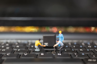 Close-up of figurines on computer keyboard