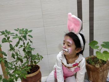 Portrait of smiling girl holding pink potted plant