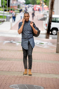 Portrait of man standing on footpath